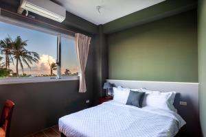 a bedroom with a bed and a large window at 都蘭 海鄰民宿 Dulan Cove in Donghe