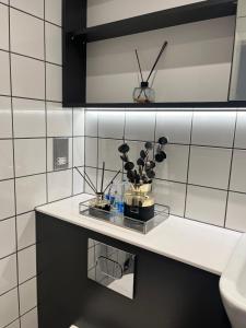 a bathroom with a counter with a vase of flowers on it at Birmingham City Center View in Birmingham