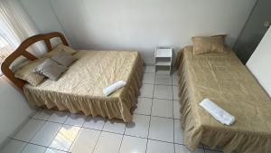 a small bedroom with two beds and a tiled floor at Pousada Ribeiro 2 in Belém +1 photo