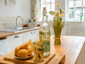 eine Flasche Wasser und ein Teller mit Zitronen auf einem Tisch in der Unterkunft Stoney Cottage in Loftus