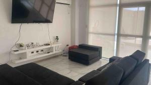 a living room with a couch and a tv at Casa con todos los servicios in San Nicolas