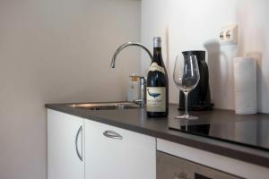 une bouteille de vin et un verre sur un comptoir de cuisine dans l'établissement Arctic View 2-Bedroom Apartment, à Tromsø