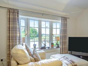 a living room with a couch and a window at The Paddock in Bodelwyddan