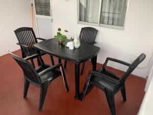 a black table with four chairs and a table with a plant on it at Double G Motel in Weligama
