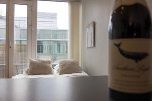 Una botella de vino sobre una mesa junto a una ventana. en Cozy Studio in Central Tromsø, en Tromsø