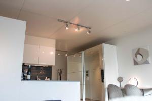 Una cocina con gabinetes blancos y una mesa con sillas. en Cozy Studio in Central Tromsø, en Tromsø 20 fotos más