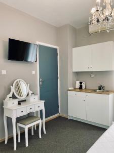Habitación con tocador, mesa y espejo. en Garden of Apollo, en Korinthos