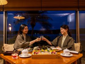 two women sitting at a table with a plate of food at Haifu in Shima