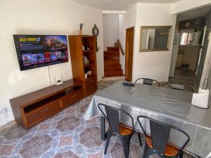 a living room with a table and chairs and a tv at Duplex 3 con cochera privada y parrilla in San Clemente del Tuyú