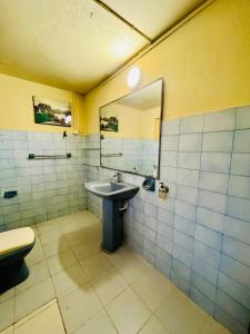 une salle de bain avec un lavabo et un miroir dans l'établissement Peaceful Haven Cozy Retreat, à Nugegoda