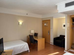 a hotel room with a bed and a desk and a chair at Guarulhos flat services, aeroporto in Guarulhos +15 photos
