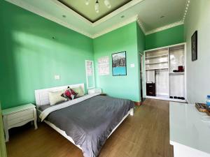 una camera da letto con pareti verdi e un letto in esso di Horizon Coffee-Homestay Đà Lạt a Xuan An
