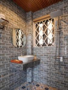 a bathroom with a sink in a brick wall at Tam Coc Little Charm Villa & Bungalow in Văn Lâm