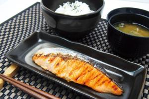 a plate with a piece of fish and a bowl of soup at Hotel Lotus Yokohama in Yokohama