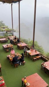 un gruppo di persone seduti ai tavoli a mangiare cibo di Horizon Coffee-Homestay Đà Lạt a Xuan An