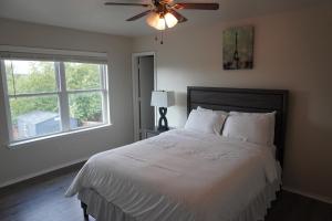 una camera da letto con un letto con un ventilatore a soffitto e una finestra di Peaceful Family Retreat Near AT&T Stadium, Texas Rangers, Six Flags, Epic Waters Indoor Waterpark, DFW Airport & More! ad Arlington Altre 49 foto
