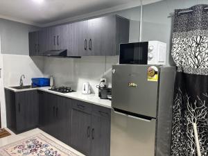 a kitchen with a stainless steel refrigerator and cabinets at Cocos Stay Executive Studio Flat in Labasa