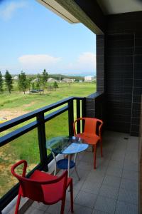 a balcony with two chairs and a table and a view of a field at Love Door 168 in Huxi