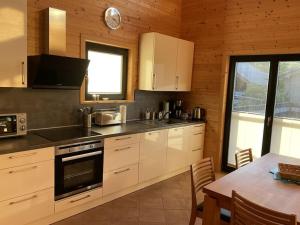 a kitchen with white cabinets and a table with a dining room at Holiday home in Rieden with swimming pool in Rieden