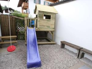 a playground with a slide and a wooden house at Holiday apartment Kranzberg in Mittenwald