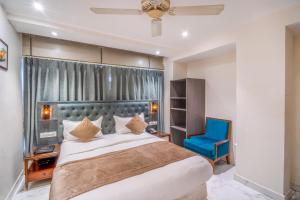 a bedroom with a large bed and a blue chair at The White Seasons in Gwalior +77 photos