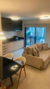 a living room with a couch and a table at Apt 1 Quarto Luxuoso - Gyro Vaca Brava in Goiânia