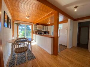 a kitchen with a table and a refrigerator at La petite maison sur l'Isle in L'Isle-aux-Coudres