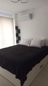 a bedroom with a large bed with a black comforter at Apt 1 Quarto Luxuoso - Gyro Vaca Brava in Goiânia
