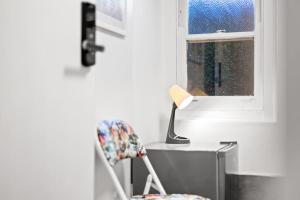 a chair sitting next to a desk with a lamp at Perfect for Travelers - Detached Double Room - Shared Bathroom in Killara
