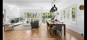 a dining room and living room with a table and chairs at 6 Bedroom Californian Bungalow in Melbourne