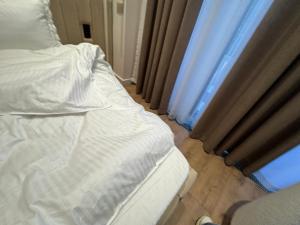 an unmade bed in a room with a window at 3vbabur in Yakkasaray
