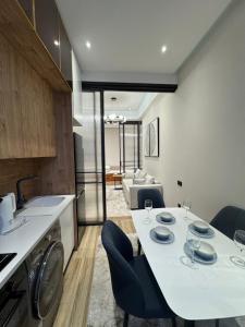 a kitchen and living room with a table and chairs at 3vbabur in Yakkasaray