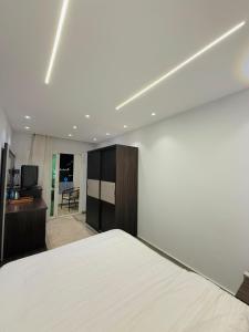 a bedroom with a white bed and a television at Kayan Pyramids View in Cairo