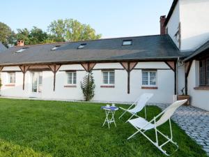une maison avec deux chaises et une table dans la cour dans l'établissement Chambre Sarcelle au manoir près de la Loire - FR-1-590-317, à Guilly 17 autres photos
