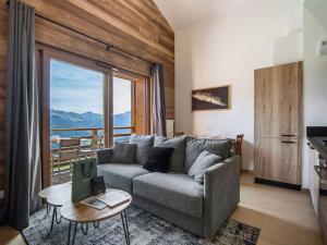 a living room with a couch and a large window at Appartement T2 confort 4 pers., parking inclus - FR-1-809-29 in Les Saisies +2 photos