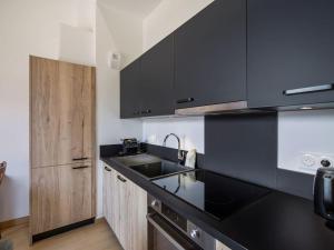 a kitchen with black counter tops and a sink at Appartement T2 confort 4 pers., parking inclus - FR-1-809-29 in Les Saisies
