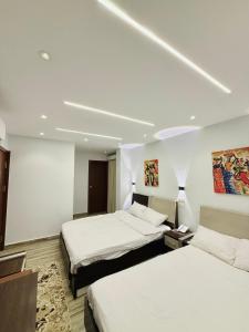 a hotel room with two beds with white sheets at Kayan Pyramids View in Cairo +77 photos