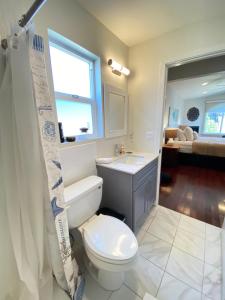 Un baño con inodoro, lavabo y ventana. en Spacious One Bedroom Near San Francisco, en Richmond