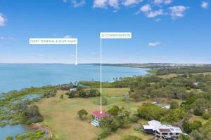 an aerial view of a house and the water at Beachfront Hervey Bay Homestead in River Heads