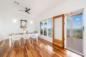 a white dining room with a table and chairs at Beachfront Hervey Bay Homestead in River Heads