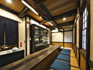 a bar with a wooden counter and blue rugs at 割烹旅館月茂登 in Kakegawa