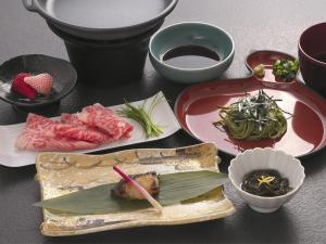 a table topped with plates of food and bowls at 割烹旅館月茂登 in Kakegawa