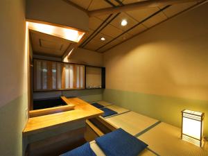 a japanese room with a sauna with blue mats at 割烹旅館月茂登 in Kakegawa
