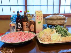 two plates of food on a table with bottles of alcohol at 割烹旅館月茂登 in Kakegawa