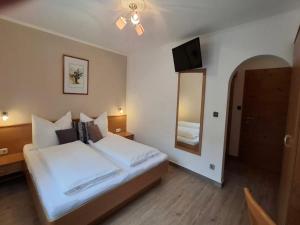 a bedroom with a large white bed and a mirror at Country House Charm near Ski Lift in Enkerbichl +30 photos