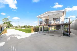 een huis met een balkon bovenop een patio bij Bay Breeze Beachhouse in Scarness