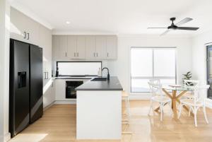 een keuken met een zwarte koelkast en een tafel bij Bay Breeze Beachhouse in Scarness