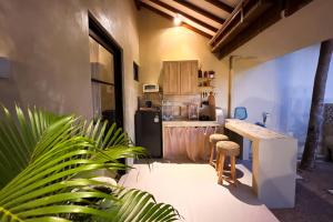 a kitchen with a counter and a refrigerator at Ubu Villa Lemme with Rustic Mediterranean Style in Adi Sutjipto