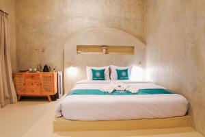 a bedroom with a bed with a stuffed animal on it at Ubu Villa Lemme with Rustic Mediterranean Style in Adi Sutjipto +10 photos