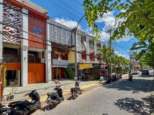eine Reihe von Motorrädern, die auf einer Stadtstraße geparkt sind in der Unterkunft AB Hotel Kuta in Kuta